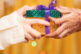 Close up of Brother Hands Giving gift to sister during during raksha Bandhan, Bhai Dooj or Bhaubeej Indian religious festival .